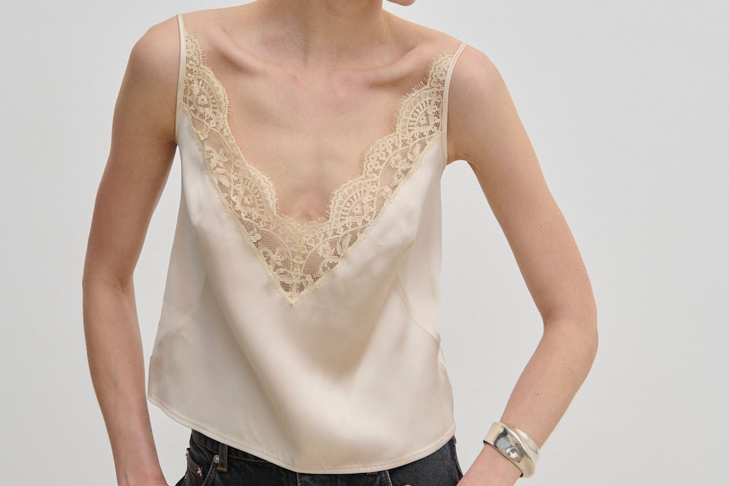 Filippa Top cream-colored camisole with a lace V-neckline and adjustable straps.